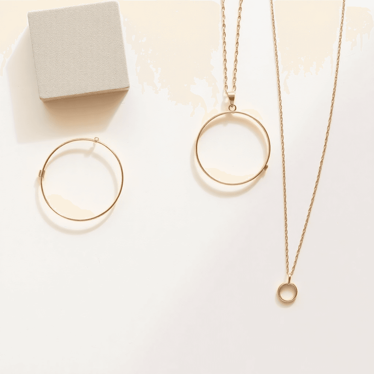 A collection of minimalist jewelry, including delicate gold bracelets and understated necklaces, beautifully arranged on a clean, neutral background.